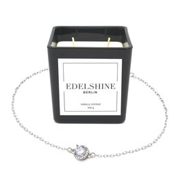 Large scented candle with a classic silver bracelet featuring a charm with a sparkling crystal.