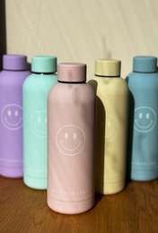 Reusable drinking bottle with smiley face design, available in various pastel colors including pink, yellow, and turquoise.
