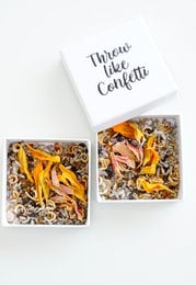 Throw like confetti bloemzaad - hardbox. Seed product with a box containing dried flowers and a tassel decoration.