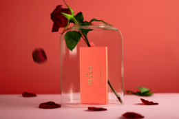 Natural rose-scented incense sticks in a glass container with rose petals.