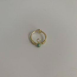 Elegant gold-tone statement ring with green and white stones, perfect for adding a touch of style to any outfit.