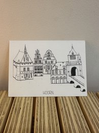 Postcard depicting the historic town of Hoorn, Netherlands, featuring traditional Dutch architecture with gabled roofs and towers.