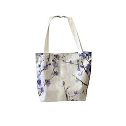 Lilac stone tote bag with zip pocket. Made of durable material with a floral print design, featuring a zip pocket for storage.