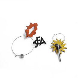 Mismatched hoop earrings with colorful cork charms: orange flower, yellow daisy, black star shapes. Gold and silver options available.