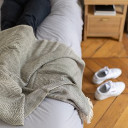  Cozy gray and white woven throw blanket with fringe detail, suitable for use on a bed or sofa.