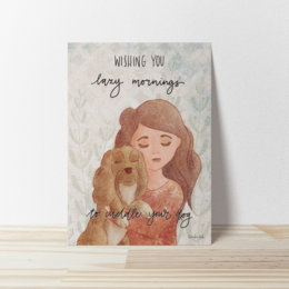 A greeting card with an illustration of a woman hugging a dog, with the text "Wishing you long snuggles" on the front.
