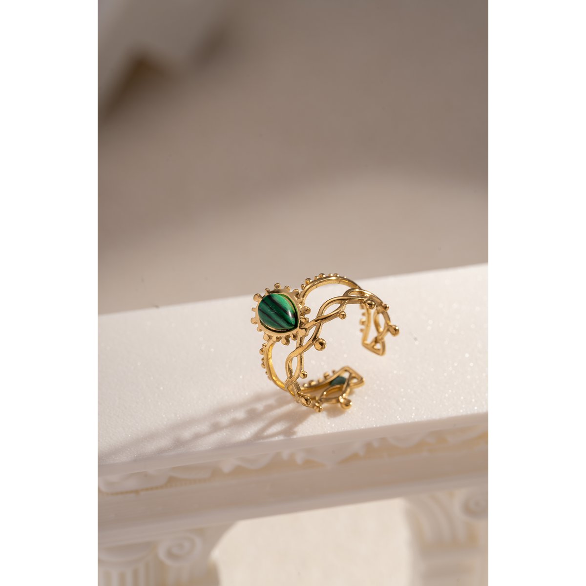 Golden stalen ring geopend met kleurrijke steen