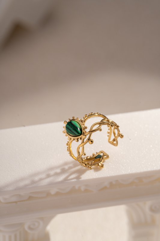 Golden stalen ring geopend met kleurrijke steen