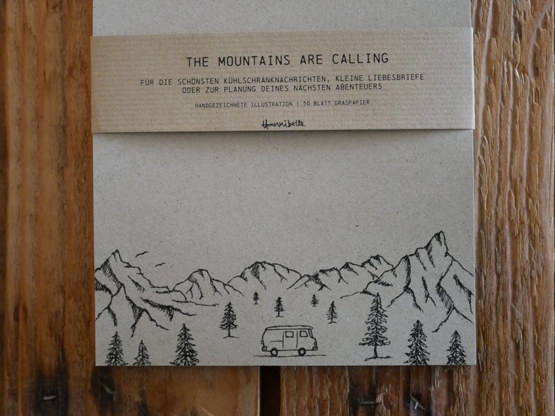 Camper con blocco note in carta erba in montagna