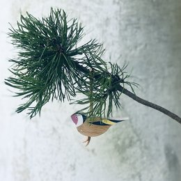 Ornamental bird figurine with vibrant colors and intricate details, featuring a goldfinch design.