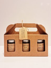 A trio of scented candles in a wooden gift box. The candles come in various fragrances and are presented in a rustic, natural-looking package.