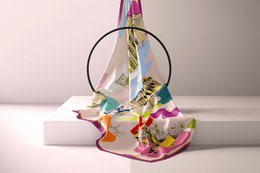 100% silk scarf in a vibrant, colorful pattern featuring stripes and abstract shapes. The scarf has a soft, luxurious feel and is suitable for wearing as an accessory or for decorative purposes.
