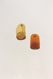 Stud earrings in amber and orange colors, featuring a simple, minimalist design.