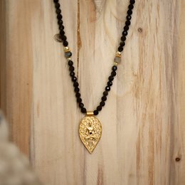 Black obsidian beaded necklace with a gold-colored leaf-shaped pendant.