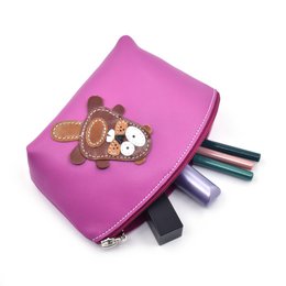  A handmade full grain leather makeup bag in a warm brown color, featuring a cute raccoon design applique.