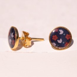 Stud earrings with a Chūrippu pattern featuring a round, purple-colored design with small floral accents in shades of red and blue. The earrings have a gold-tone metal setting.