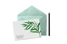 A greeting card with the text "Success!" and a green leaf design on a white background, enclosed in a mint green envelope.