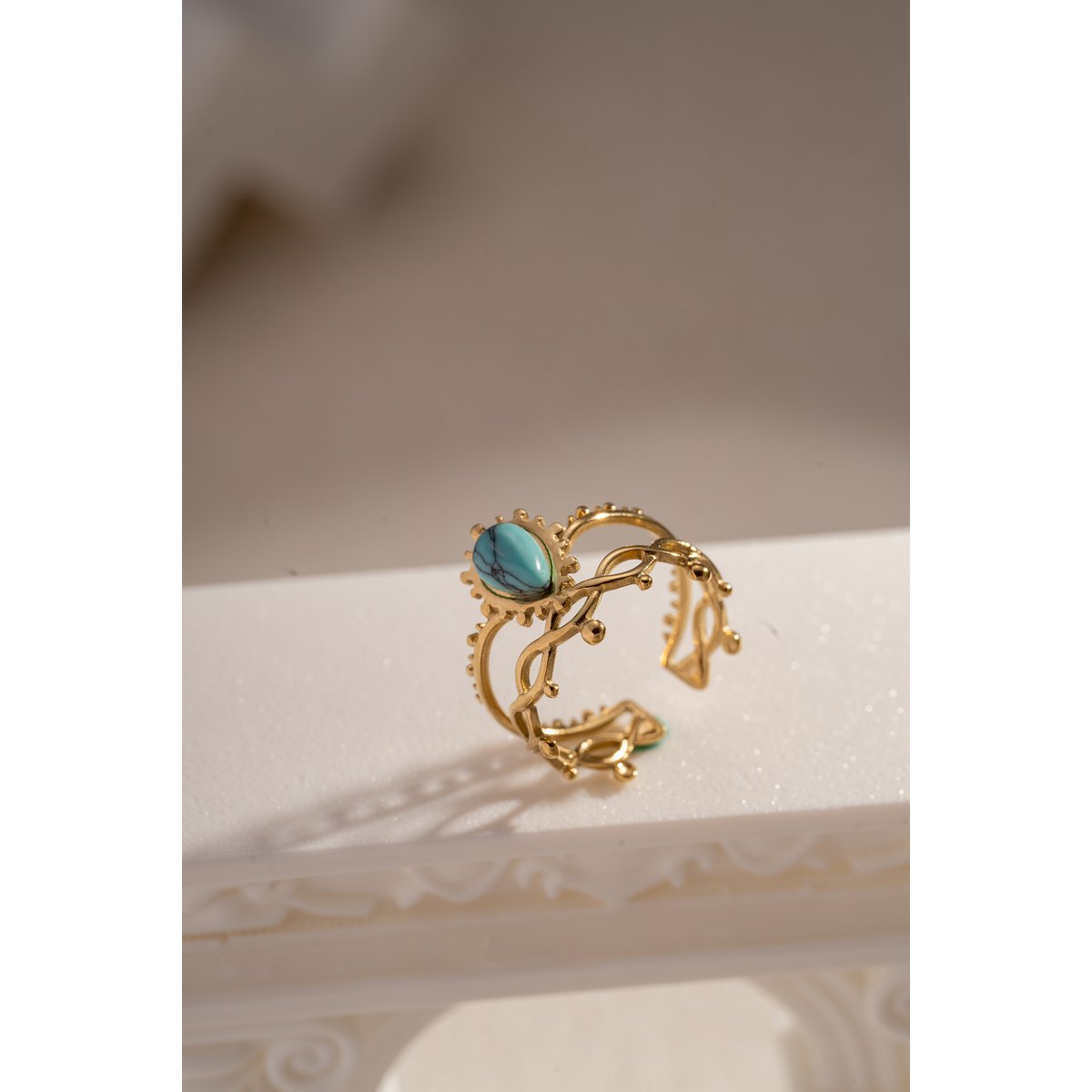 Golden stalen ring geopend met kleurrijke steen