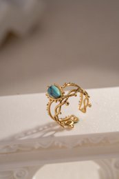Golden stalen ring geopend met kleurrijke steen
