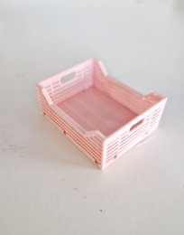 Wooden storage crate for dolls, featuring a pink color and a rectangular shape. Suitable for organizing and storing doll accessories.