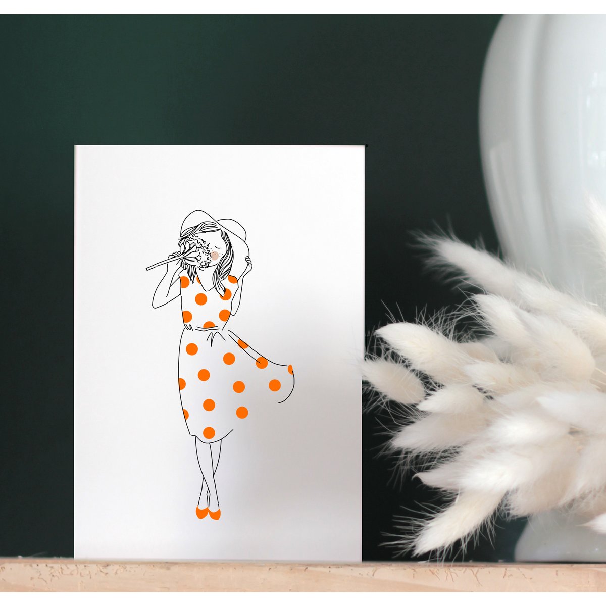Card Mireille - Mujer con sombrero blanco y vestido de guisantes rojos huele una flor