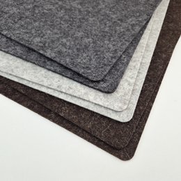 Rectangular natural wool felt placemats in black and grey colors.