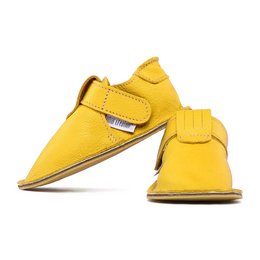 Zippy - uni soleil slippers in a vibrant yellow color. These slippers feature a simple, minimalist design with a velcro strap closure for easy on and off. The rounded toe shape provides a comfortable fit.