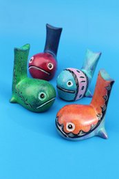 Colorful soapstone whale statue, featuring a round, compact shape and vibrant orange and green hues. Suitable for decorative display.