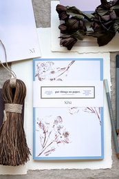 Blank notebook with damson purple and dusky pink floral design framing the cover.