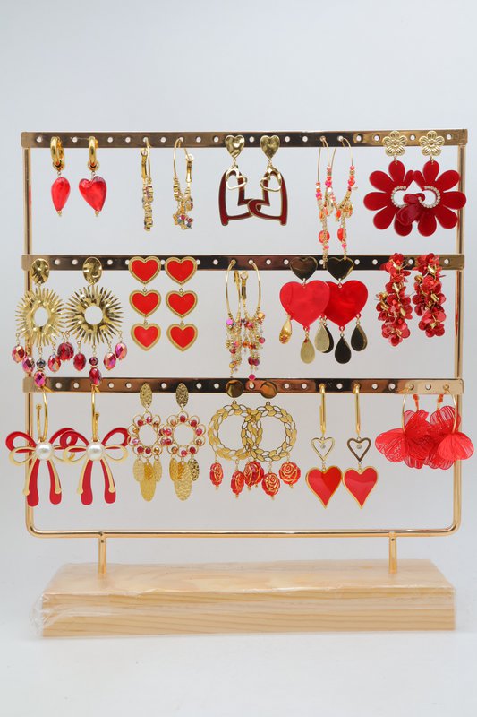Assortiment de 15 paires de boucles d'oreilles de couleur rouge assorties, en acier inoxydable, montées sur un présentoir métallique avec un socle en bois.