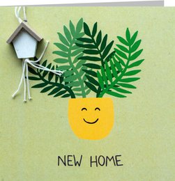 Greeting card with a cheerful pineapple design and the text "NEW HOME". The card features green leaves or fronds, a wooden birdhouse, and a smiling pineapple icon, creating a welcoming and nature-inspired aesthetic.