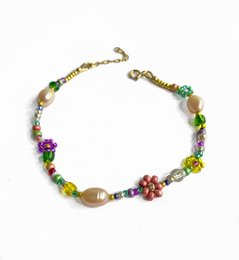 Colorful floral bracelet with pink and pearl beads
The bracelet features a delicate floral design with pink and pearl beads, creating a feminine and elegant accessory. The mix of colors and materials adds visual interest and texture to the piece.