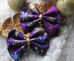 Purple and gold glittery hair barrettes with snowflake designs, perfect for the holiday season. Includes details on the materials, style, and shape of the accessories.