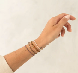  Handmade gemstone bracelet with amethyst, sunstone, moonstone, tiger eye, and rose-quartz beads. Elegant and versatile accessory.