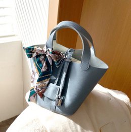 A stylish and versatile 2-in-1 handbag in a choice of 3 colors - blue, brown, and beige. The bag features a structured silhouette, a detachable scarf accent, and multiple compartments for organization.