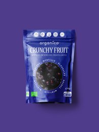 Dried blueberries in a package and a bowl, featuring a natural, rustic wooden background. The blueberries appear dark in color and crunchy in texture.