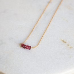 A delicate gold-filled necklace with a row of vibrant pink tourmaline gemstones, perfect for adding a touch of color and elegance to any outfit.