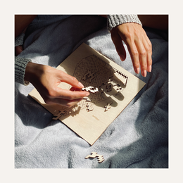 Geometric puzzle with intricate pattern. Hands working on a puzzle with a complex, abstract design.