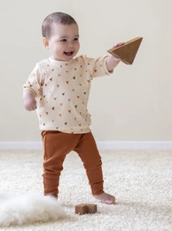 Cognac rib fine trousers, kids pants in sizes 50, 92, 86, 80, 74, 68, 62, 56, featuring a baby in a polka dot top and brown pants playing with wooden blocks.
