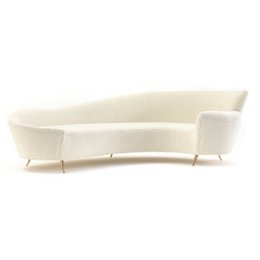 Curved cream white sofa, modern curved design, upholstered seating, mid-century style furniture.
