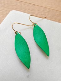 Grass green statement earrings with a twist design and gold-tone hardware.