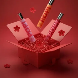 Red patchouli perfume bottles with floral clover design, vibrant pink and red color scheme, luxury fragrance set.