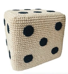 A round, off-white and black dotted cotton pouf, hand-crocheted in Nepal, suitable for use as a kids' stool.