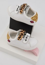  White sneakers with leopard print and gold accents. Suitable for casual wear.
