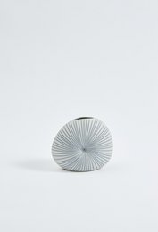 Tall, round white ceramic vase with a ribbed texture and a minimalist design.