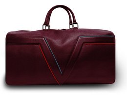 Burgundy leather travel bag with blue and red trim, designed for weekend getaways.