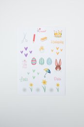 Colorful sticker sheet featuring various spring-themed designs including Easter eggs, flowers, and crowns.