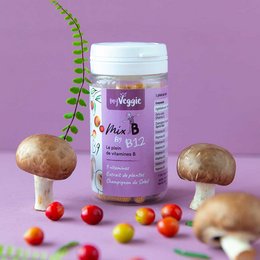 White pill bottle with "My Veggie Mix B" label, surrounded by mushrooms, cherry tomatoes, and a plant stem on a purple background.