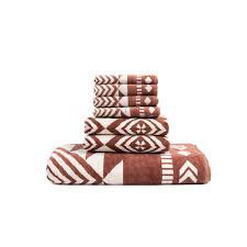 A set of brown and white patterned bath towels, including a bath towel, hand towels, and face towels. The towels feature a geometric, tribal-inspired design with stripes, diamonds, and other abstract shapes.