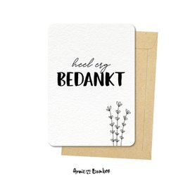A simple, minimalist postcard with the text "heel erg bedankt" (thank you very much) and a small floral illustration. The postcard is made of white cardstock with a natural kraft envelope.